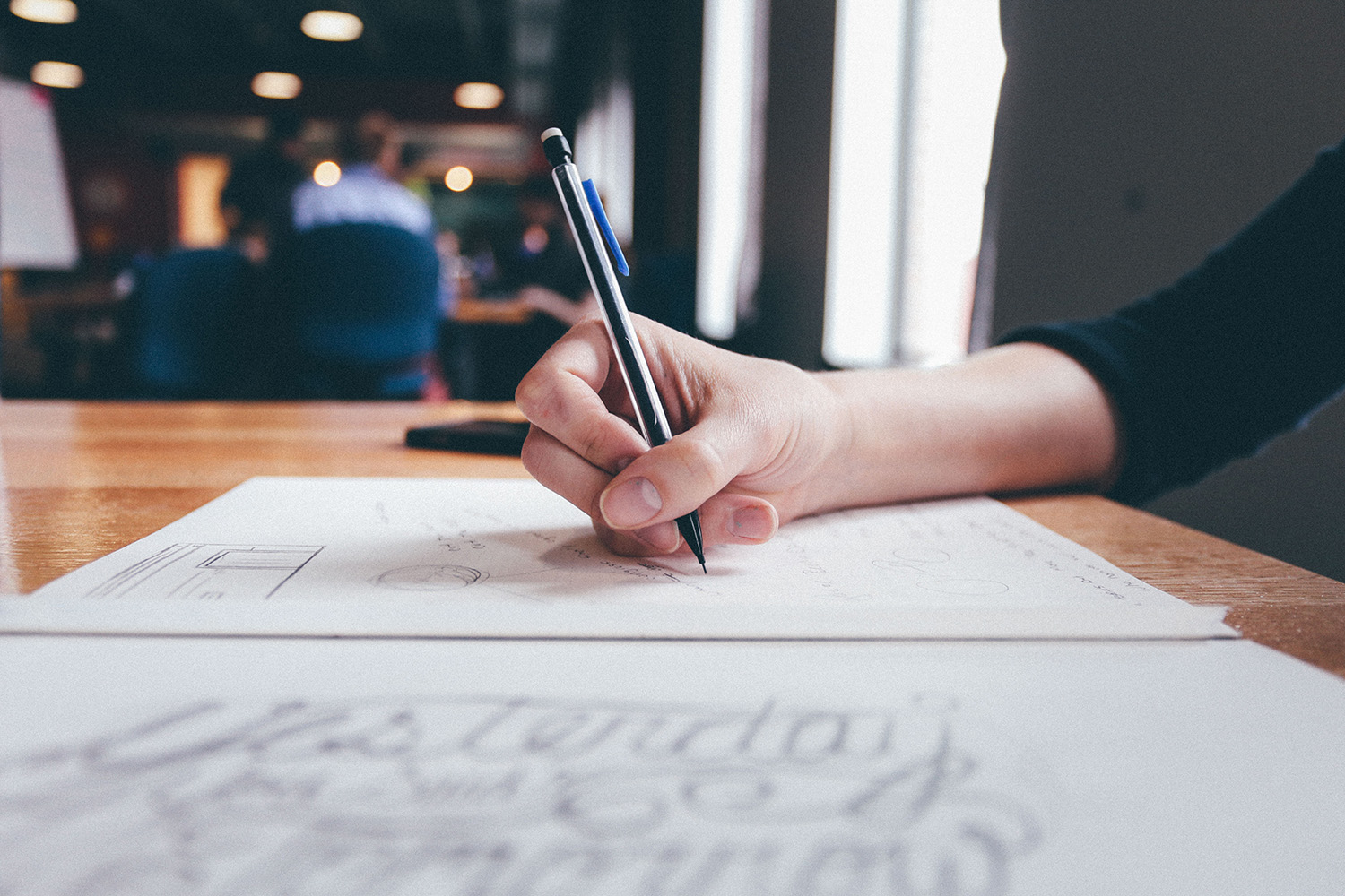 Woman at desk writing in a notebook