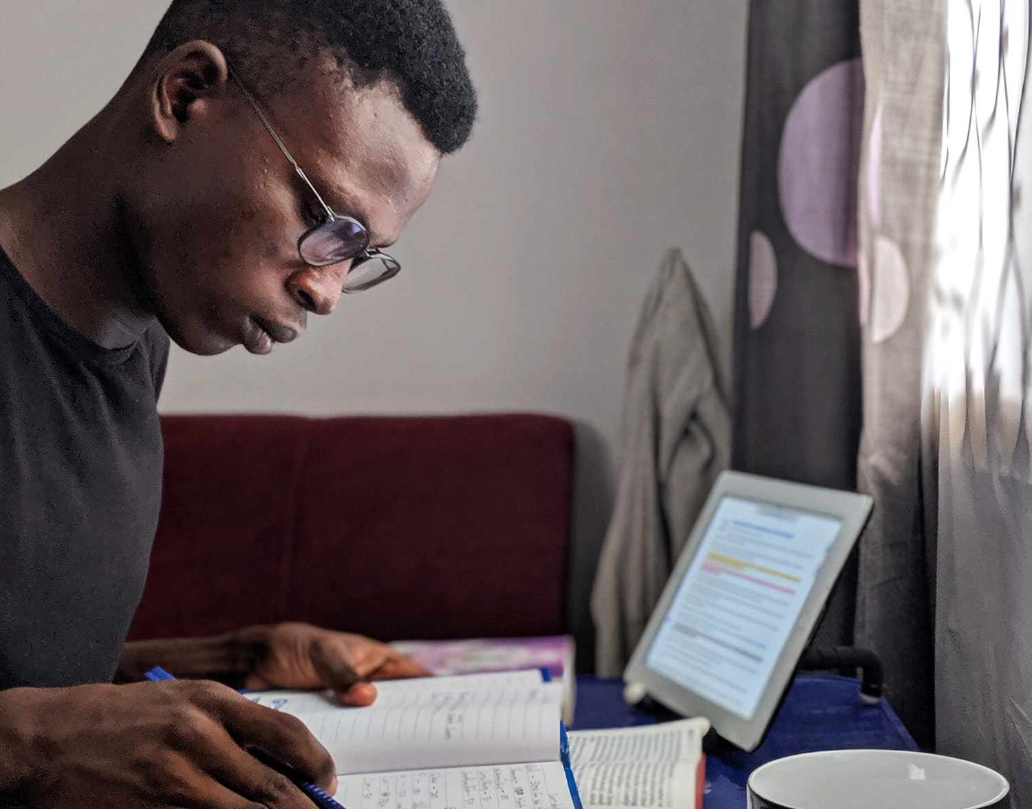 Man at desk studying with books