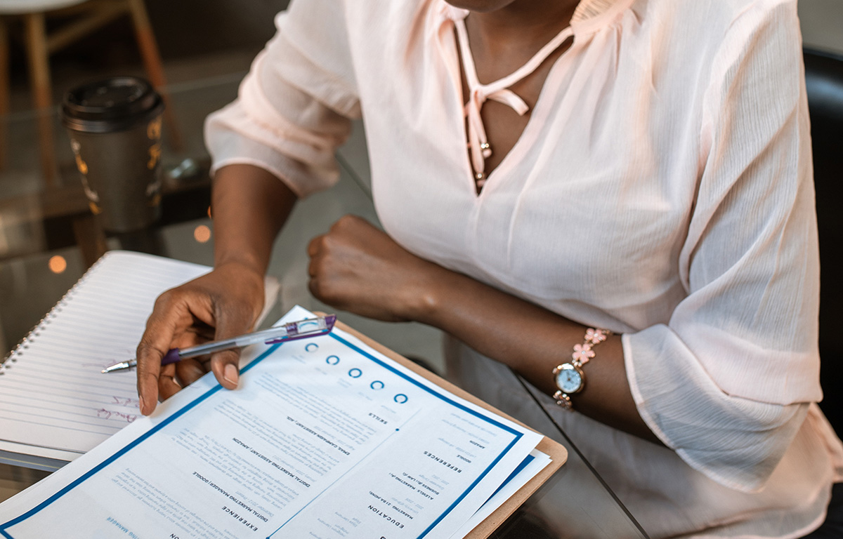 Woman reviews resume on clipboard